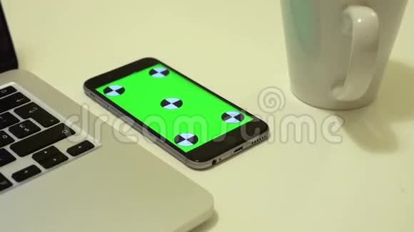 智能手机位于办公桌上屏幕上有色度键视频的预览图