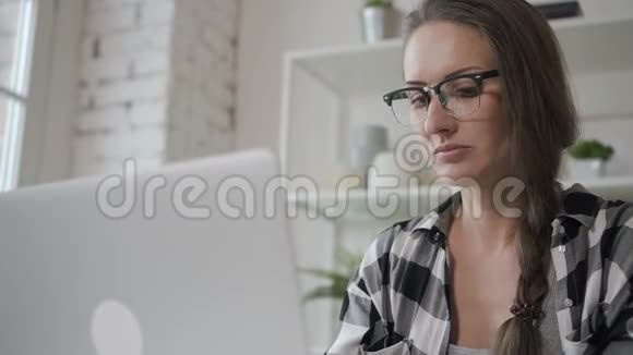 年轻的企业主女性在家里的桌子上坐着笔记本电脑视频的预览图