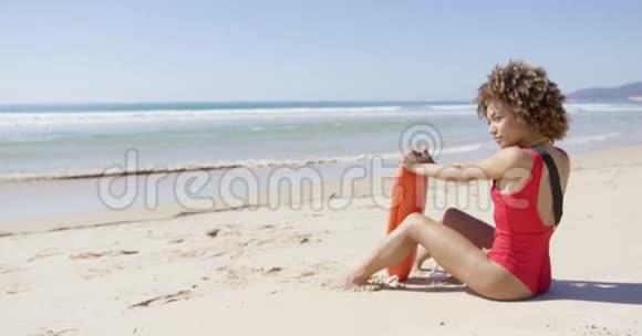 有救生浮子的女人坐在沙滩上视频的预览图