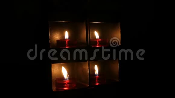 在天主教教堂的黑暗中在一个特殊的壁龛里燃烧着美丽的红色圆形祈祷蜡烛视频的预览图