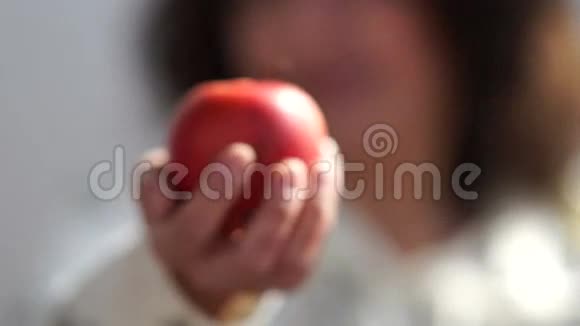 女人在白色背景下举起红苹果视频的预览图