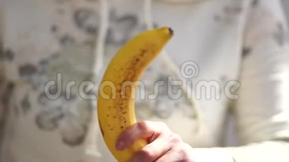 香蕉出现在女人手中女性清洁香蕉视频的预览图