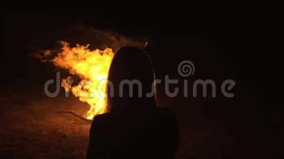神秘女人黑色背景的剪影火焰火花轮廓轮廓户外慢速运动视频的预览图
