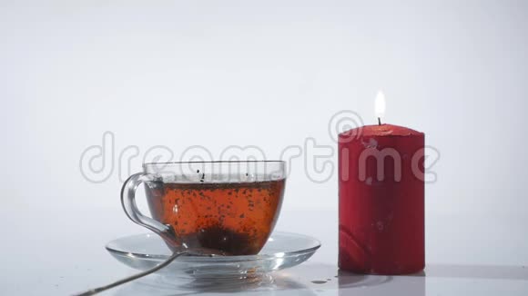 茶杯白色背景上点燃红色蜡烛视频的预览图