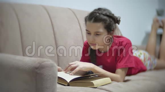 十几岁的女孩躺在沙发上看书躺在沙发上看书的女孩视频的预览图