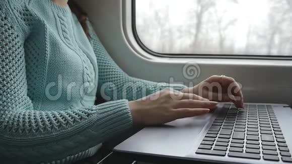 女性手在火车上使用笔记本电脑的触摸板年轻女性在旅行中触摸笔记本触摸屏的手臂视频的预览图