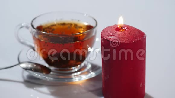 茶杯白色背景上点燃红色蜡烛视频的预览图