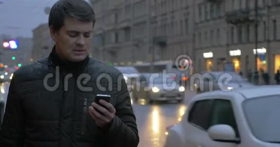 晚上雨市有手机的男人视频的预览图