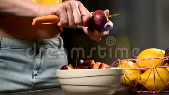 在家庭厨房里女性手的特写镜头是用一把梅花刀切下新鲜浆果并从中取出一根骨头视频的预览图