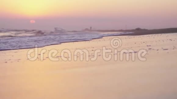 热带美丽的日落在海上海浪在海滩上缓慢地移动视频的预览图