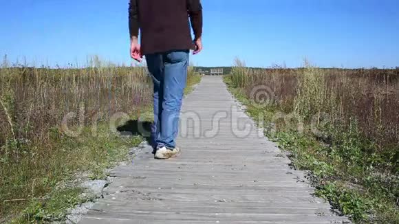 一个人走在木板人行道上视频的预览图