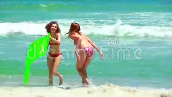 两个女孩在海滩上从水里走过来视频的预览图