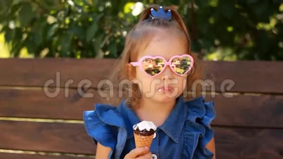 在阳光明媚的夏天小女孩戴着太阳镜吃冰淇淋婴儿特写肖像视频的预览图