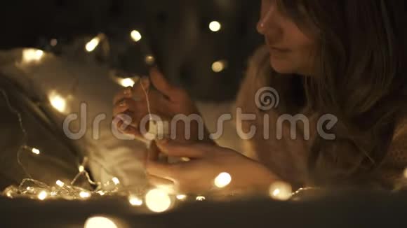 美丽的女孩在床上旋转一个圣诞雪花装饰玩具她很高兴视频的预览图