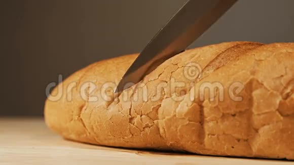 在木制桌面上用菜刀切制的新鲜烘焙面包视频的预览图