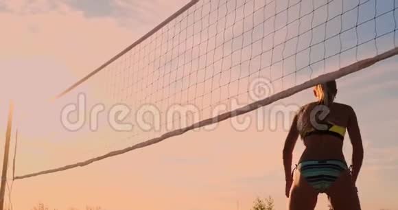一群年轻女孩在日落或日出时打沙滩排球视频的预览图