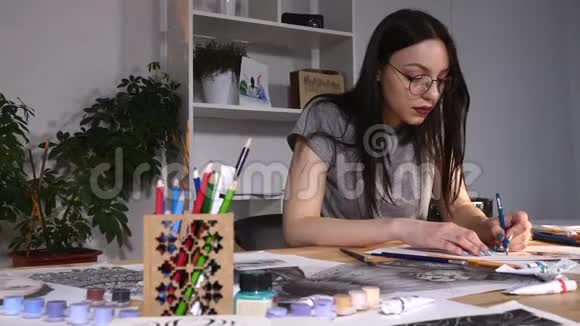 女画家正坐在办公室里画素描她戴着眼镜视频的预览图
