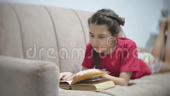 十几岁的女孩躺在沙发上看书躺在沙发上看书的女孩视频的预览图