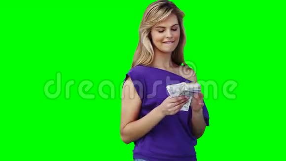 一个女人手里拿着很多现金微笑着视频的预览图