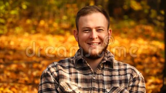 秋天一个男人在室外对着镜头微笑的照片4K视频的预览图