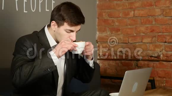 商人在笔记本电脑上工作在咖啡馆里喝咖啡视频的预览图