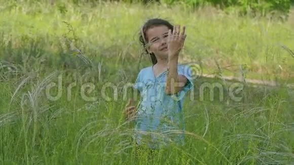 夏天草地上的女孩蹒跚学步的慢动作视频视频的预览图