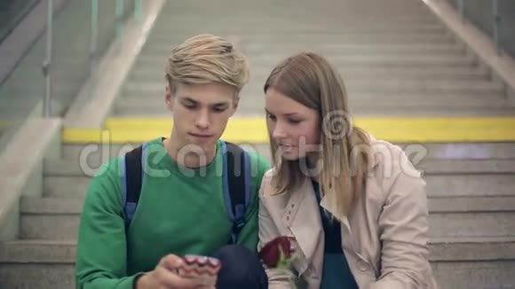 年轻的情侣坐在学院的台阶上自拍视频的预览图