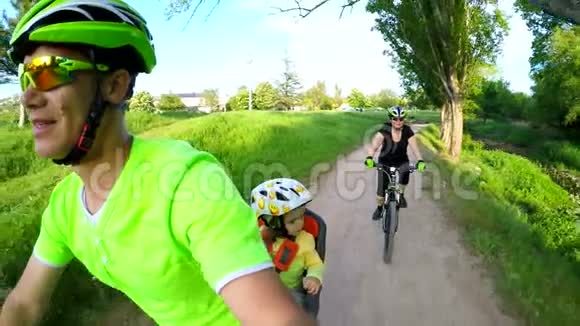 绿色公园内的家庭骑单车视频的预览图