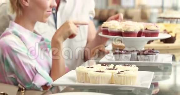 快乐的一对夫妇在餐馆里指着纸杯蛋糕视频的预览图