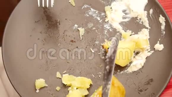 烤香肠和土豆用不锈钢刀叉在盘子里切视频的预览图