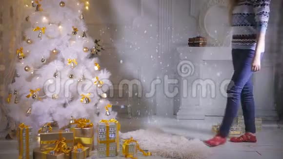 圣诞礼物圣诞树旁情绪激动的漂亮女孩现身对新年假期的到来感到兴奋视频的预览图