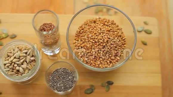 碗和玻璃杯里不同种类的种子辣椒荞麦亚麻籽视频的预览图