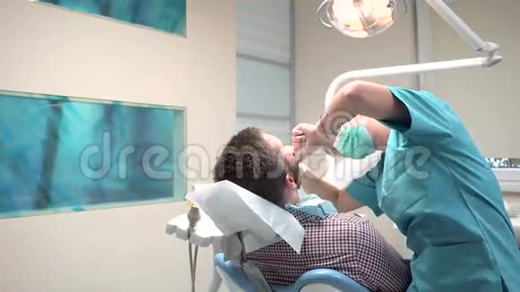 女性牙医检查男性患者的牙齿是的是的视频的预览图