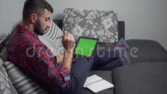 男士使用带绿屏和笔记本的平板电脑视频的预览图