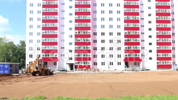 黄色拖拉机在施工现场靠近粉红色建筑视频的预览图
