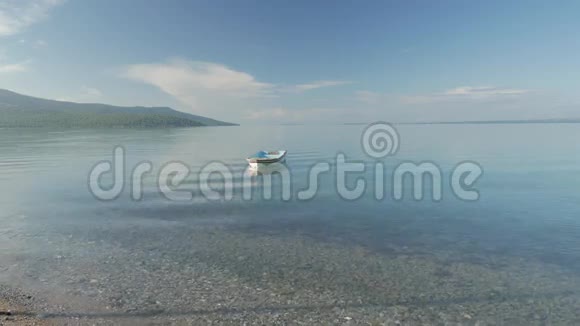 孤独的划艇在清澈的水面上漂着小船视频的预览图