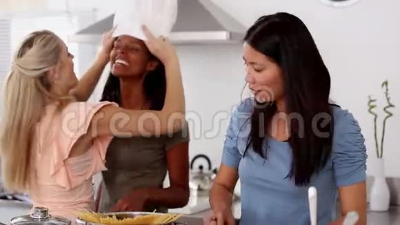女人在朋友头上戴厨师帽视频的预览图
