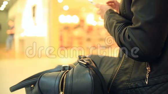 一个女人坐在购物中心的长凳上并不怀疑她的钱包狡猾的扒手偷了视频的预览图