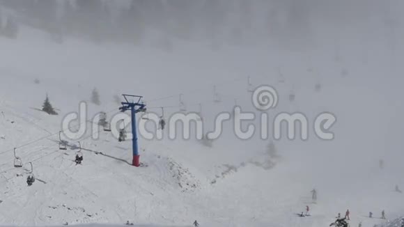 滑雪缆车将人们从云层中抬到山顶上景视频的预览图