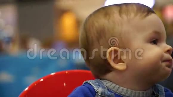 小男孩坐在儿童椅子上吃面包视频的预览图