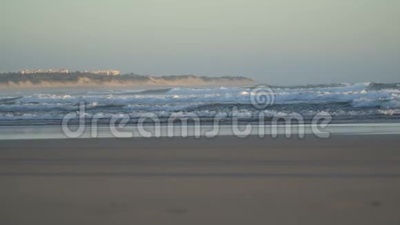 看到一个美丽的沙滩蓝色的波浪滚动到海岸一些岩石呈现视频的预览图