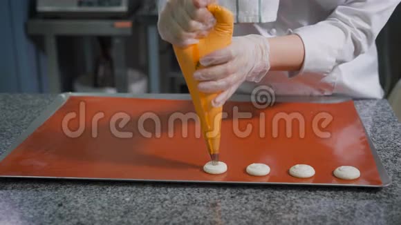带有糕点注射器的甜点师在厨房烘焙前做同样大小的饼干甲板上有生的甜点厨房视频的预览图