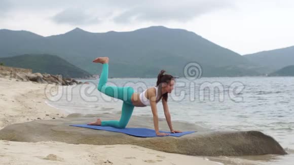 健身健康的女人在日落时在海滩上做运动锻炼视频的预览图