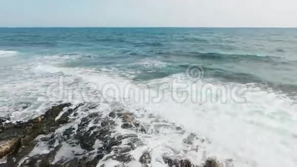 美丽的海浪空中射击飞过滚落在岩石上的波浪视频的预览图