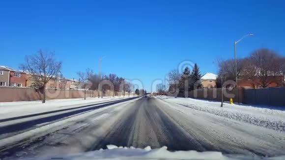 白天在雪居郊区街上开车带雪的POV郊区道路的司机视角视频的预览图