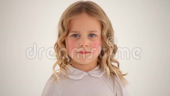 特写镜头小可爱的小女孩蹒跚学步红润的脸颊金色的卷发在镜头中微笑视频的预览图