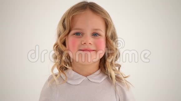 特写镜头小可爱漂亮的小女孩蹒跚学步的孩子红润的脸颊金色的卷发在镜头中微笑视频的预览图