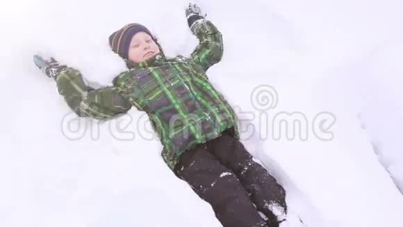 小男孩微笑着做雪天使视频的预览图