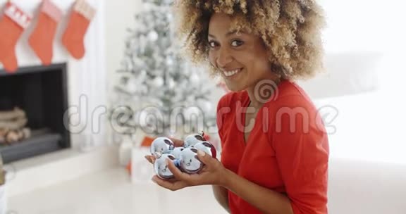 年轻女子拿着一把圣诞装饰品视频的预览图