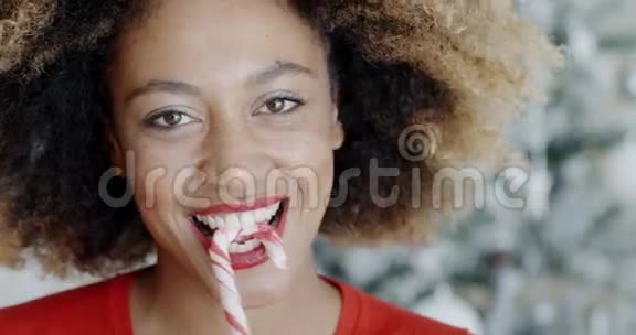 有趣的年轻女人咬圣诞糖果视频的预览图